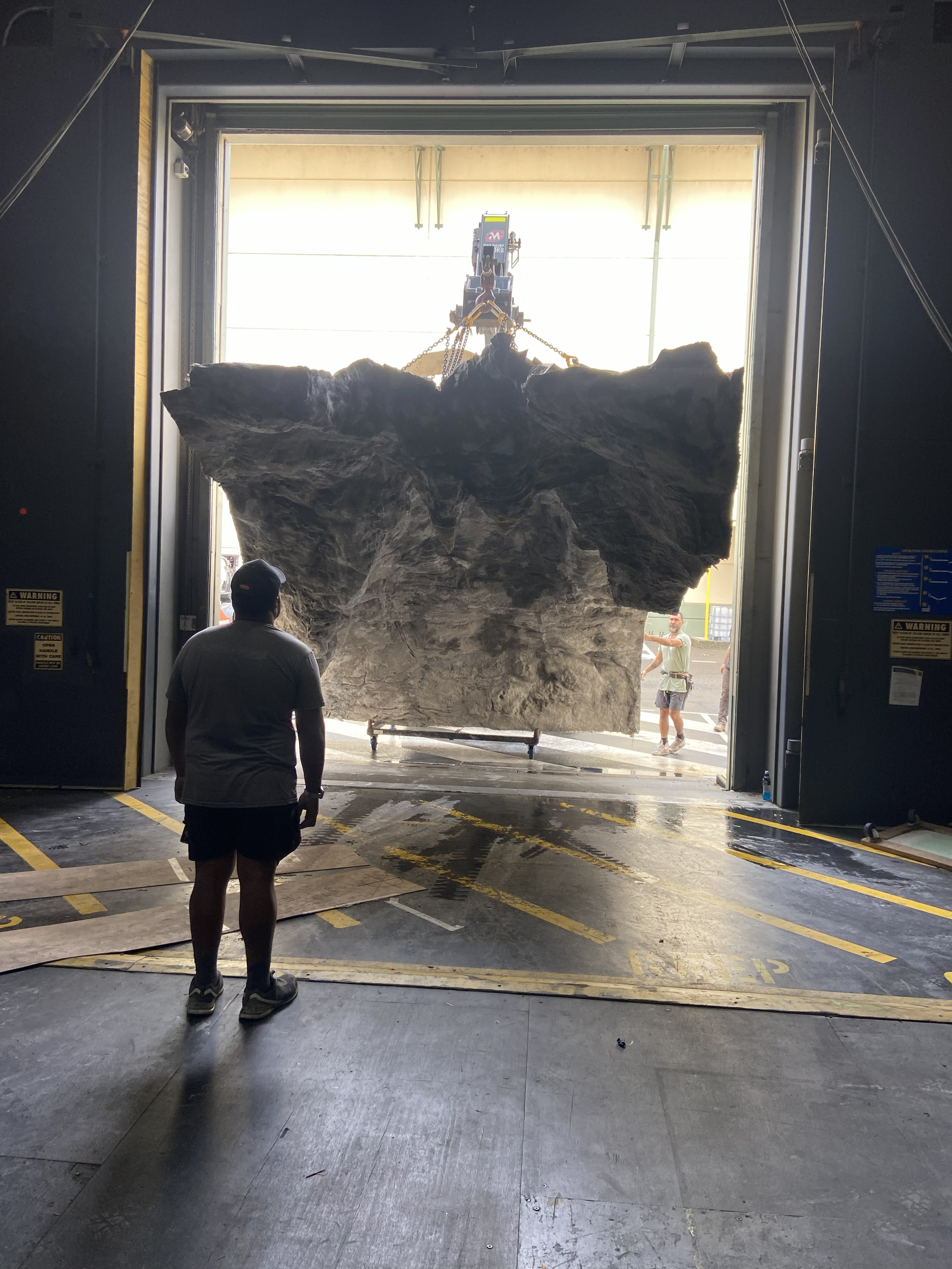 Large modular cave roof section being transferred through the soundstage door.
